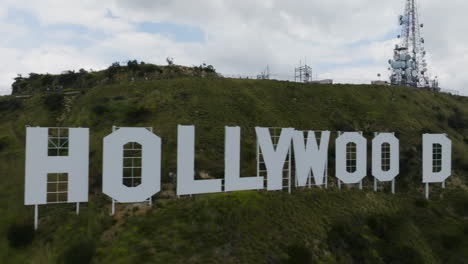 Aerial-tracking-shot-in-front-of-the-Hollywood-sign,-partly-sunny-day-in-Los-Angeles,-USA