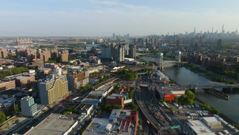 Drone-shot-over-the-Bronx-cityscape,-toward-Brooklyn,-golden-hour-in-New-York,-USA