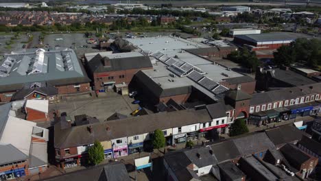 Aerial-view-above-Cheshire-town-market-street-retail-shops-and-supermarket-rooftops-during-recession