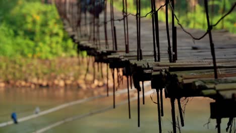 Scooter-Pasando-Por-La-Plataforma-De-Madera-Oscilante-De-Un-Puente-Colgante-En-Indonesia