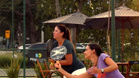 Female-couple-playing-beach-tennis-in-concentration