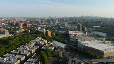 Aerial-view-over-the-cityscape-of-the-Bronx,-along-the-Harlem-river,-golden-hour-in-New-York,-USA
