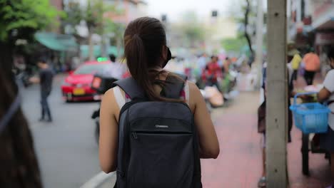 Turista-Tailandés-Mirando-A-Su-Alrededor-De-Espaldas-Con-Mochila-En-El-Mercado-De-Flores-De-Bangkok