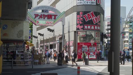 Eine-Gruppe-Von-Fußgängern-Schlendert-Und-Betritt-Die-überfüllte-Geschäftsstraße-Von-Ameya-Yokocho,-Einem-Der-Beliebtesten-Und-Wichtigsten-Märkte-Tokios,-Der-Seinen-Ursprung-Auf-Dem-Schwarzmarkt-Hat