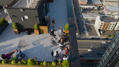 Aerial-view-of-people-sitting-on-a-condo-roof,-waving-for-the-camera,-in-New-York,-USA