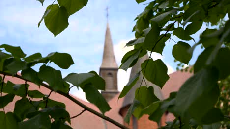 Der-Turm-Des-Heiligtums-Unserer-Lieben-Frau-Von-Gietrzwałd,-Durch-Die-Blätter-Der-Bäume-Gesehen