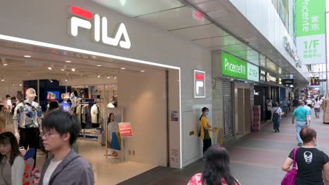 Pedestrians-walk-past-the-Italian-sportswear-goods-brand-Fila-store