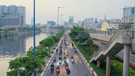 Vista-Aérea-De-La-Autopista-De-Motos-Junto-Al-Río-Con-Vista-Al-Río-Y-Edificio-En-El-Fondo-En