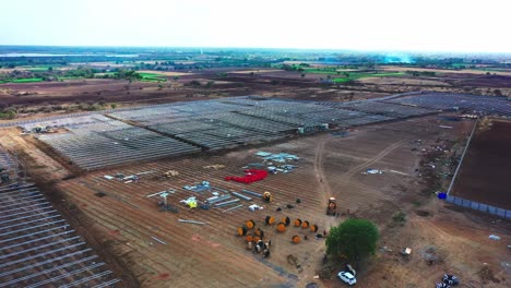 Vista-Aérea-De-Una-Gran-Central-De-Energía-Solar-Donde-Muchos-Trabajadores-Están-Procesando-La-Instalación-Ubicada-En-La-India.