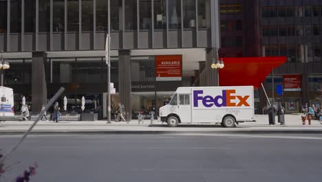 Chicago,-USA---15-march-2023:-Street-with-FedEx-truck-parked,-cars-driving-by-in-the-daytime-traffic