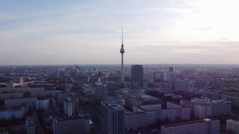 Establishing-aerial-view-orbiting-Alexanderplatz-Berliner-Fernsehturm-tower-and-cityscape-skyline-during-blue-hour