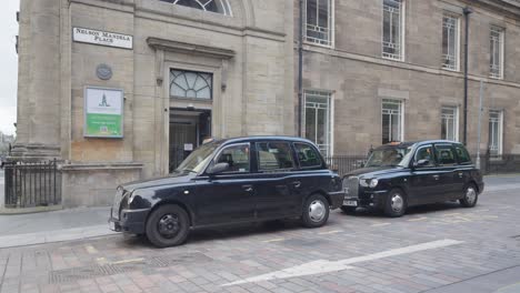 Dos-Taxis-Negros-De-Glasgow-Estacionados-En-El-Centro-De-La-Ciudad