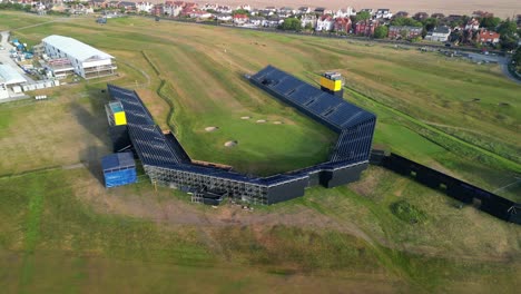 Preparations-for-The-2023-Open-at-Royal-Liverpool-Golf-Club,-Wirral,-UK---Aerial-drone-18th-green-pull-back-and-slow-clockwise-pan