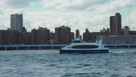 -NYC-Ferry-Travelling-Across-East-River-Under-Bridge-In-NYC