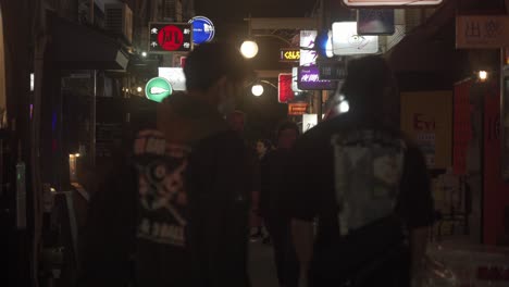 View-Looking-Down-Along-Golden-Gai-Street-In-Shinjuku-At-Night-With-People-Walking-Past