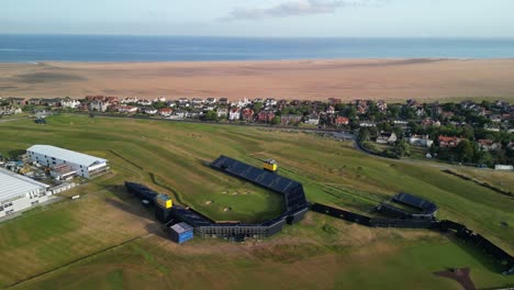 Preparativos-Para-El-Abierto-De-2023-En-El-Club-De-Golf-Royal-Liverpool,-Wirral,-Reino-Unido---Drone-Aéreo-Número-18-Verde-En-Sentido-Antihorario-Desde-Arriba-Y-Lejos,-Revelación-Del-Campo-Y-El-área