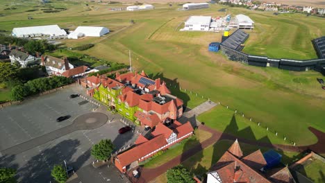 Preparations-for-The-2023-Open-at-Royal-Liverpool-Golf-Club,-Wirral,-UK---Aerial-drone-clubhouse-clockwise-pan-from-high-and-far,-course-reveal