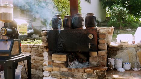 Large-Turkish-kettles-brewing-tea-on-smoking-hot-wood-fired-oven-outdoors