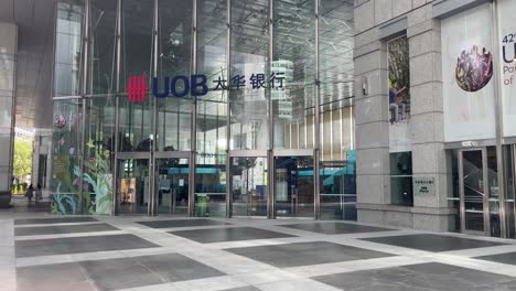 Das-UOB-Logo-Am-Eingang-Des-UOB-Gebäudes-Präsentiert-Eine-Mischung-Aus-Moderner-Architektur-Und-Zeitloser-Eleganz-Am-Raffles-Place,-Einem-Wahrzeichen-Im-Herzen-Des-Zentralen-Geschäftsviertels-Von-Singapur
