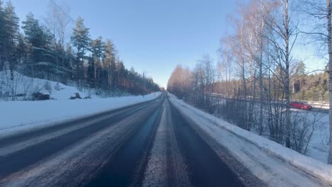 Ein-Auto-Fährt-Entlang-Der-Straße,-Flankiert-Von-Schneebedeckten-Bäumen,-Die-Eine-Malerische-Winterlandschaft-Schaffen