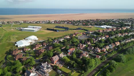 Preparations-for-The-2023-Open-at-Royal-Liverpool-Golf-Club,-Wirral,-UK---Aerial-drone-flyover-to-course-from-Hoylake,-Meols-Drive