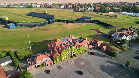 Preparations-for-The-2023-Open-at-Royal-Liverpool-Golf-Club,-Wirral,-UK---Aerial-drone-clubhouse-anti-clockwise-fast-pan-from-far,-course-reveal