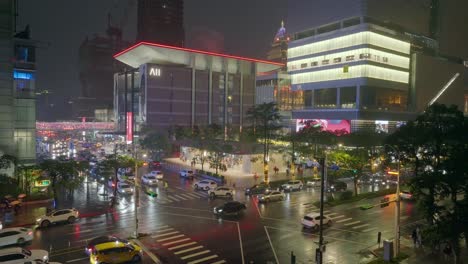 Toma-Aérea-De-Establecimiento-De-Un-Cruce-Concurrido-En-La-Ciudad-De-Taipei-Durante-El-Día-Lluvioso-Por-La-Noche
