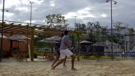 A-player-jumps-into-the-air-to-hit-the-ball-in-beach-tennis