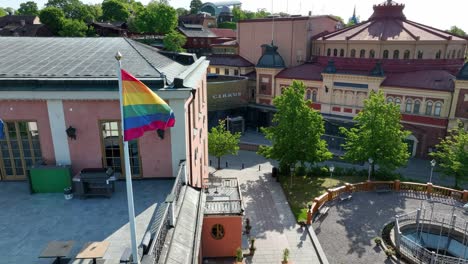 La-Bandera-Del-Orgullo-Gay-Del-Arco-Iris-Ondea-Con-Orgullo-En-El-Viento-Y-El-Sol-En-La-Parte-Superior-Del-Edificio-Del-Hotel-En-Estocolmo,-Suecia---Hotel-Hasselbacken-En-Djurgarden