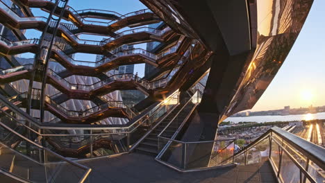 FPV-view-of-walking-up-spiral-staircase-of-Vessel-at-sunset,-Manhattan,-NYC
