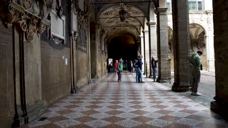Tourists-Visiting-Palazzo-dell’Archiginnasio-In-Bologna-Underneath-Portico