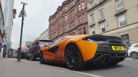 Coche-Deportivo-Mclaren-Naranja-Estacionado-En-Una-Calle-De-La-Ciudad-De-Glasgow