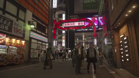 Gente-Caminando-Por-La-Noche-A-Través-Del-Principal-Barrio-Rojo-De-Kabukicho,-Japón,-En-Tokio,-Letreros-De-Neón-Y-Vida-Nocturna