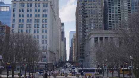 Street-with-traffic,-public-transport-and-busy-people,-downtown-american-city-with-tall-buildings