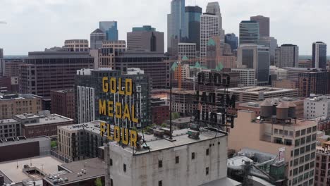 Nahaufnahme-Der-Parallaxenschwenk-Luftaufnahme-Der-Goldenen-Metallmehlbeschilderung-In-Der-Innenstadt-Von-Minneapolis,-Minnesota