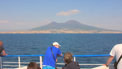 Passengers-looking-at-the-view-of-Mount-Vesuvius-from-the-boat,-Italy