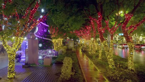 Aerial-backwards-shot-of-flashing-decorated-Christmas-trees-in-city-of-Taipei-at-night-during-rainy-day