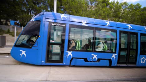 Station-with-arriving-blue-public-transportation-tram,-recorded-at-Les-Hauts-de-Massane,-neighborhood-in-Montpellier,-France