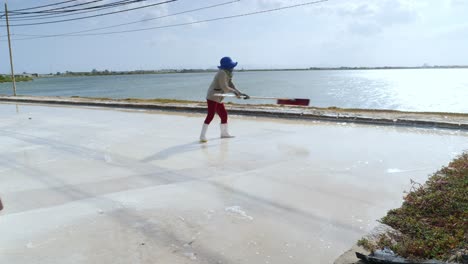 Dos-Agricultores-De-Sal-Marina-Están-Cosechando-Sal-Marina