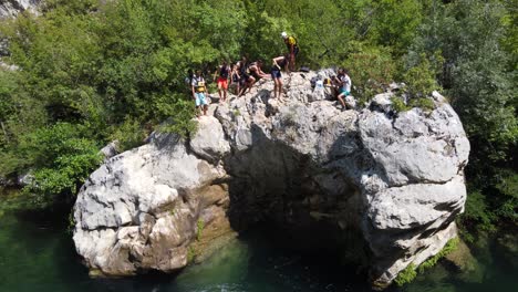 Acantilado-De-Jóvenes-Saltando-De-Una-Roca-Después-De-Hacer-Rafting-En-El-Río-Cetina-En-Omis,-Croacia