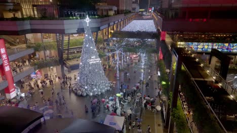 Aerial-flyover-Xmas-decorated-shopping-center-with-many-people-at-night---Taipei-City,-Taiwan-in-december