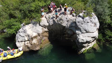 Person-jumping-off-cliff-head-first-into-water-at-white-water-Rafting-excursion-in-Cetina-River,-omis---Croatia