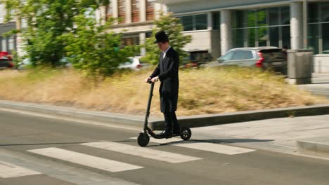 Young-Orthodox-Jew-on-electric-scooter-in-the-city-streets-of-the-Antwerp's-diamond-district,-Belgium