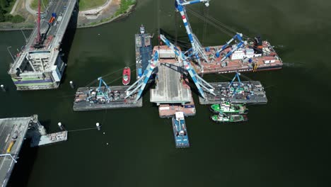 Drone-footage-of-the-valve-of-the-Haringvliet-bridge-hanging-in-floating-cranes,-close-up