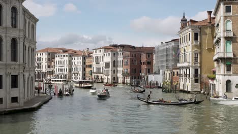 Idyllischer-Blick-Auf-Den-Canal-Grande-Von-Der-Rialtobrücke-In-Venedig-Mit-Gondolieri-Und-Booten,-Die-An-Sonnigen-Tagen-Aneinander-Vorbeifahren