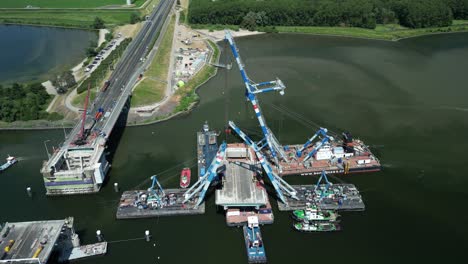 Close-up-drone-footage-of-the-valve-of-the-Haringvliet-bridge-hanging-in-floating-cranes