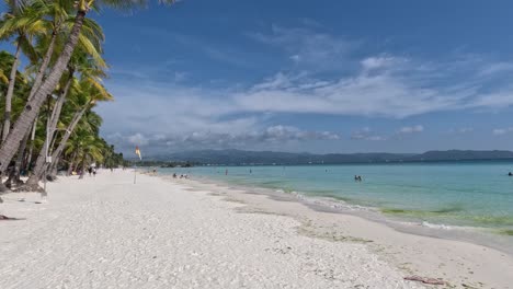 People-Swimming-and-Enjoying-the-Refreshing-Crystal-Clear-Water-at-White-Beach-in-Boracay-Island,-Philippines