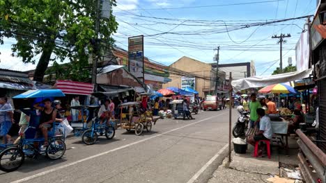 Gente-Caminando-Y-Conduciendo-Por-Una-Calle-Muy-Transitada-Junto-A-Un-Bullicioso-Mercado-Público-En-La-Ciudad-De-Danao,-Cebú,-Filipinas