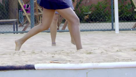 couple-playing-beach-tennis-in-a-sand-court,-outdoors,-slow-motion