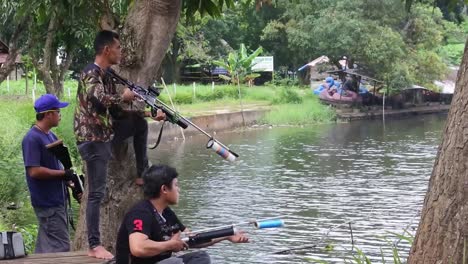 Varios-Hombres-Cazan-Peces-En-El-Borde-De-Un-Lago-Artificial-En-Depok,-Indonesia